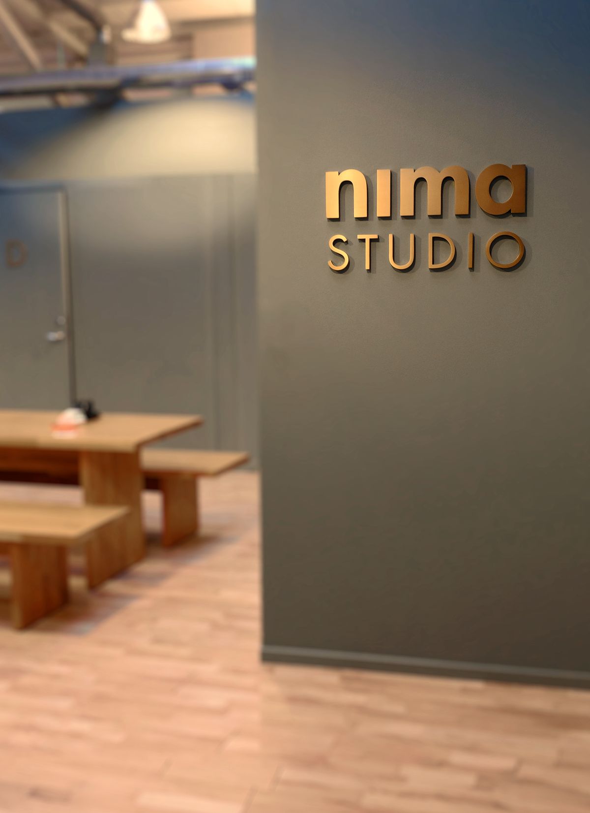 Inngangen til Nima Studio med kobberskiltet paa veggen